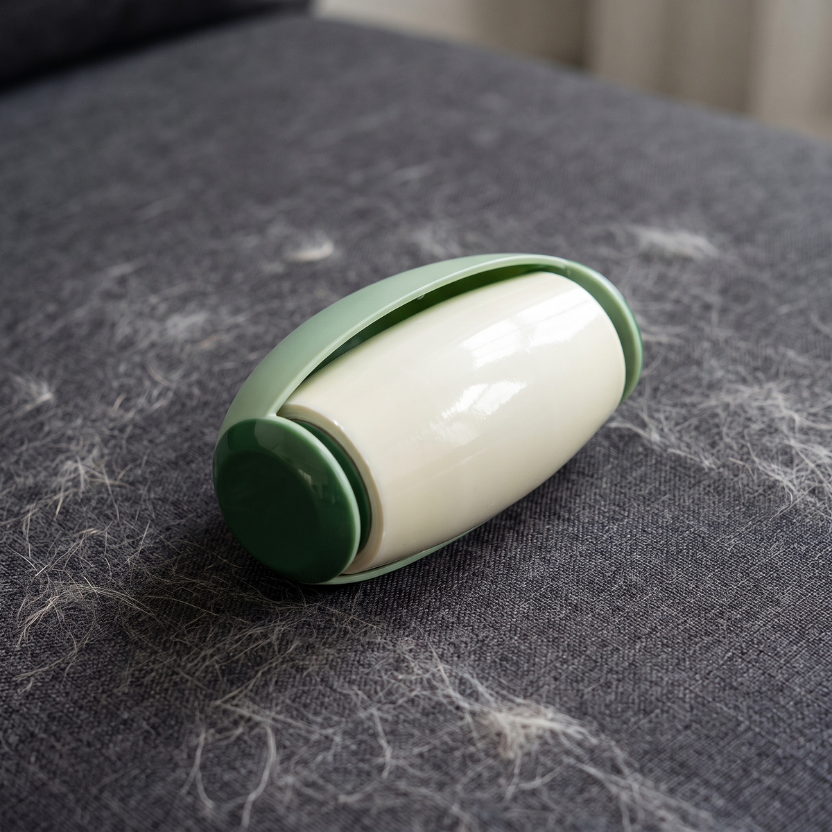 The Rinse Roller picking up pet hair on a fabric sofa